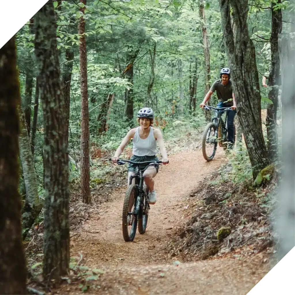 Man and woman bike down mountain trail