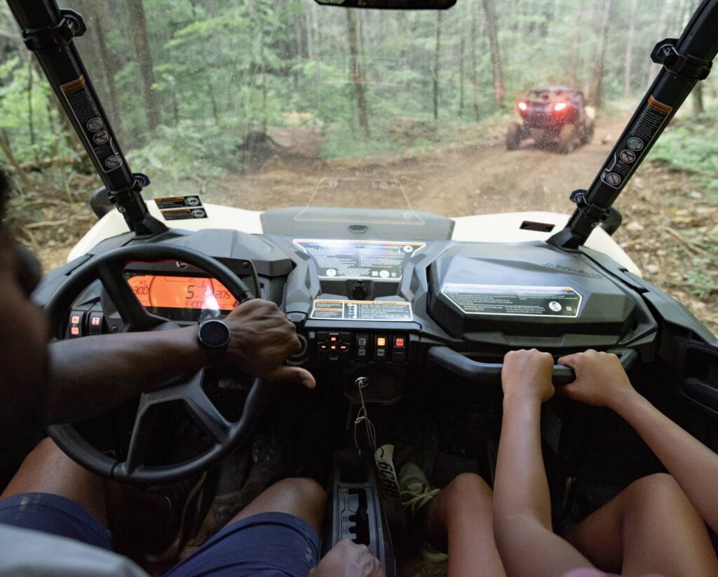 Couple riding UTV across dirt path at Wildside in East Tennessee