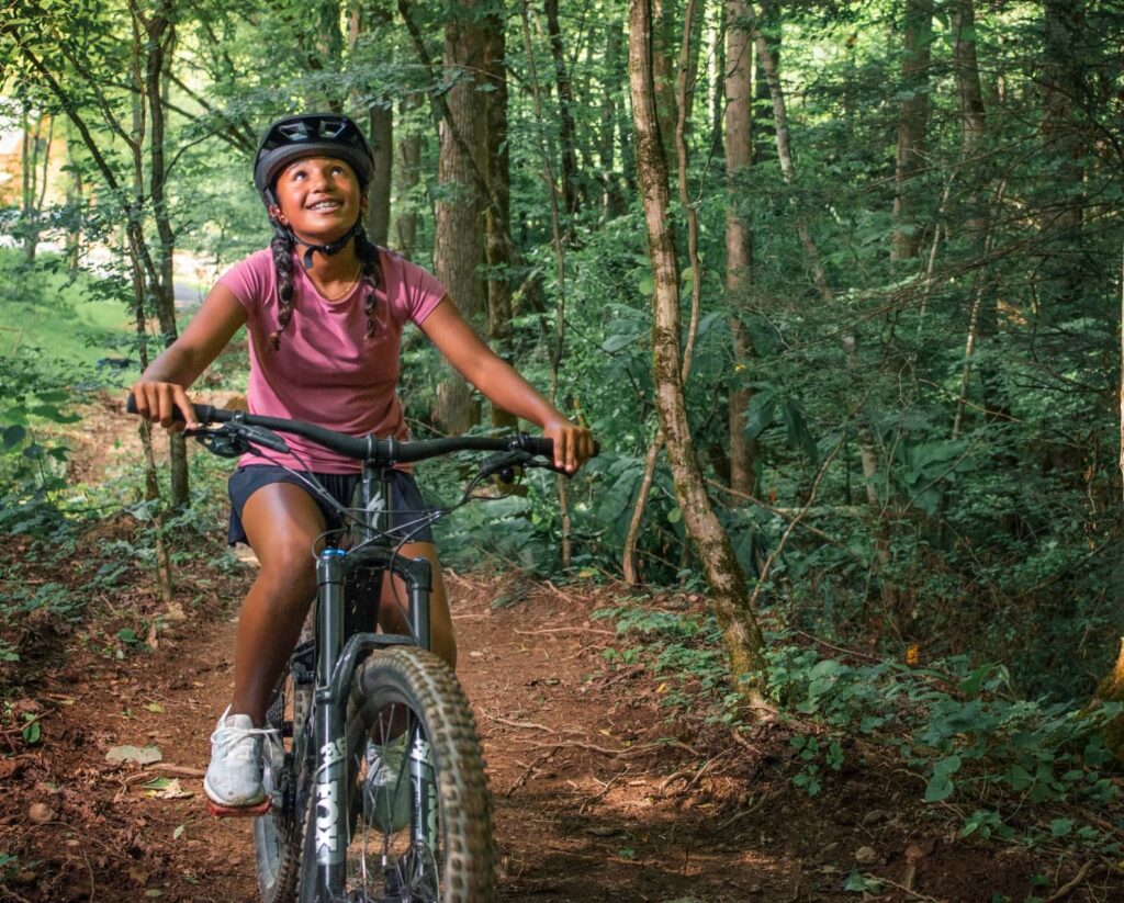 Little girl riding a mountain bike on a flat, kid-friendly trail at Wildside in East Tennessee.