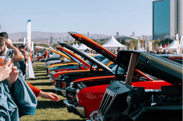 car show attendees look at the display cars